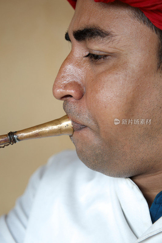 印度音乐家，演奏弯曲的小号式管乐器