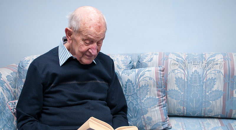 88岁的老人在读一本平装书