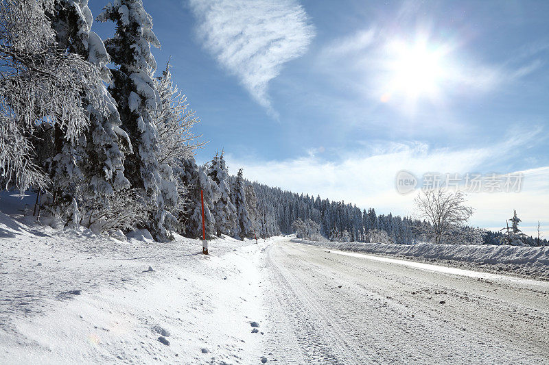 白雪皑皑的冬季景观与街道和太阳耀斑