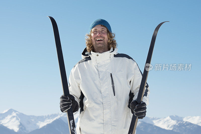 一个快乐的英俊的男人和越野滑雪户外。