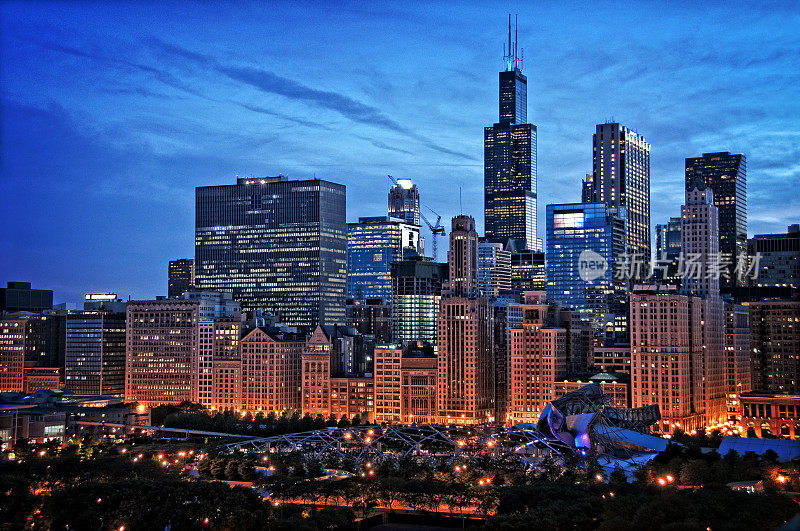 芝加哥湖滨天际线城市夜景在千年公园与戏剧性的多云天空。