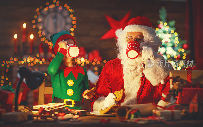圣诞节。圣诞老人和精灵一起喝牛奶，吃饼干