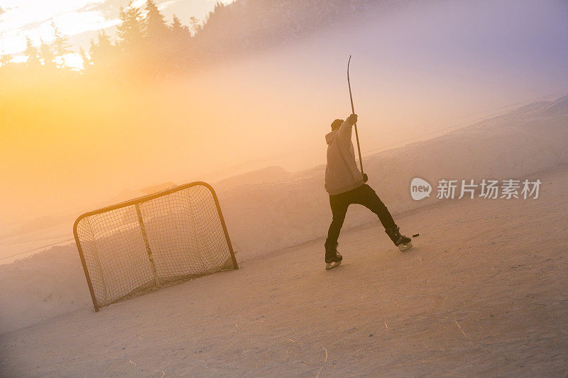 年轻人在结冰的湖面上打曲棍球。