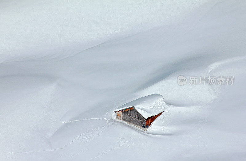 阿尔卑斯山上被雪覆盖的小木屋