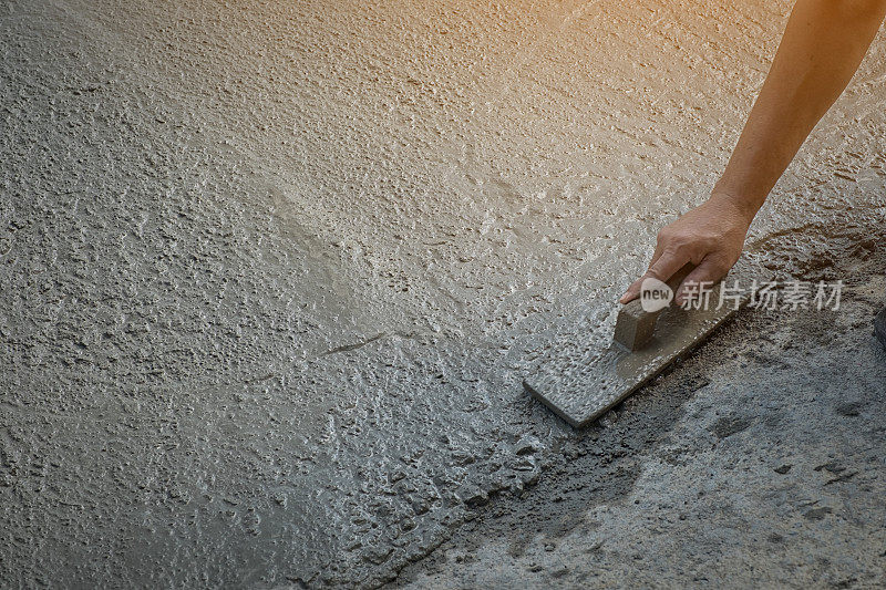 工人们不穿土靴用锄头(铁锹)在混凝土地面上挖掘，建筑工人找平混凝土路面。升级至住宅街道找平混凝土板、工作场所