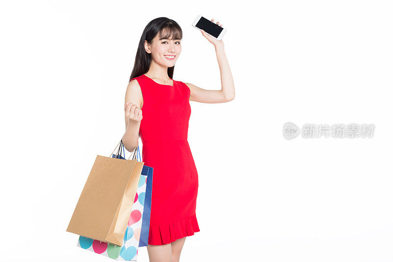 快乐的年轻女人拿着智能手机和购物袋