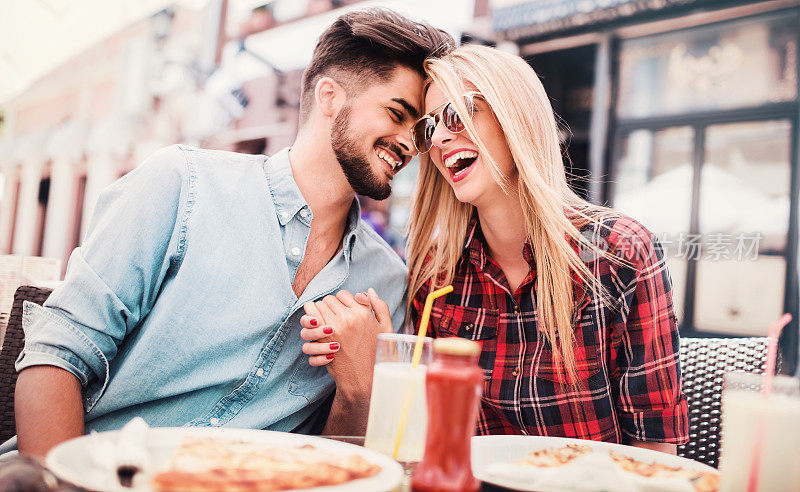 恩爱夫妻坐在咖啡馆吃披萨。消费主义、食品、生活理念