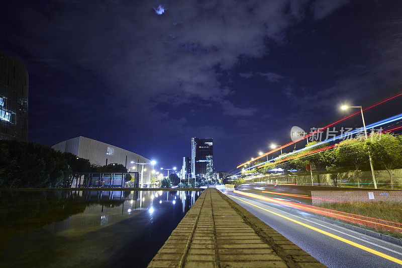 夜晚的城市街道，灯光的痕迹和水面的倒影