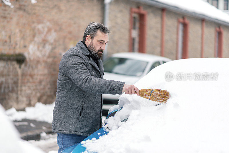 从车上清除雪的人