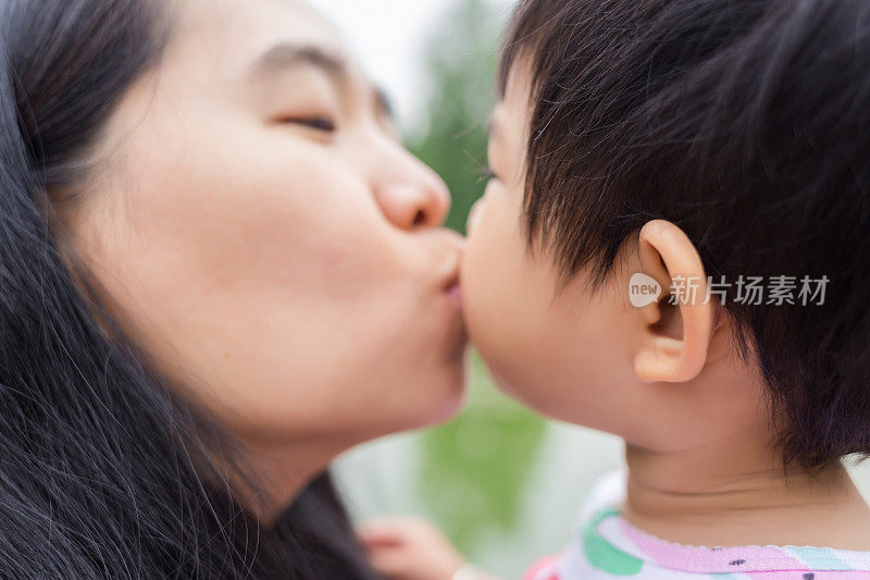 小婴儿和她的妈妈接吻