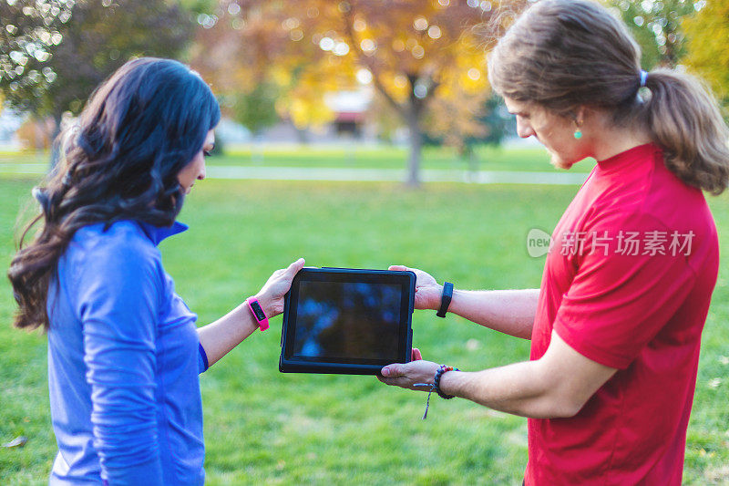 千禧一代的年轻人在公园里用科技观看iPad视频
