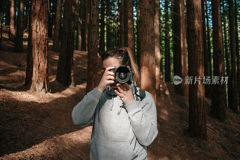 一个女人正在用单反相机拍照