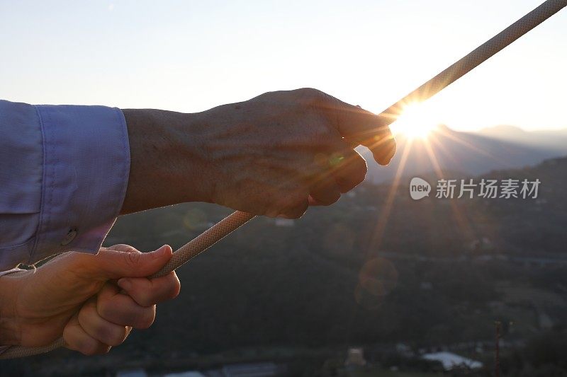 日落时，女人的手放在栏杆上