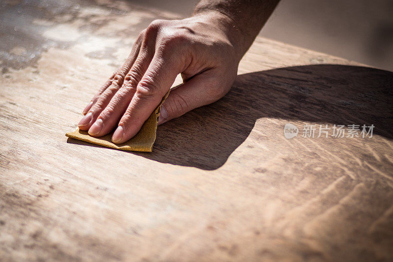 砂砾风化的人的手在打磨木头表面