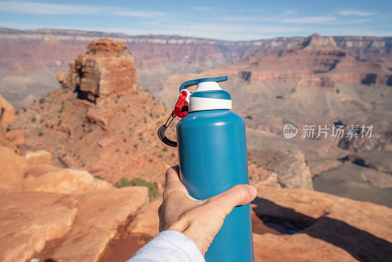 手持水瓶向大峡谷延伸的观点，旅游概念