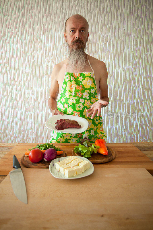 一个留着胡子，穿着围裙的有趣的家伙，展示肉和蔬菜沙拉的配料