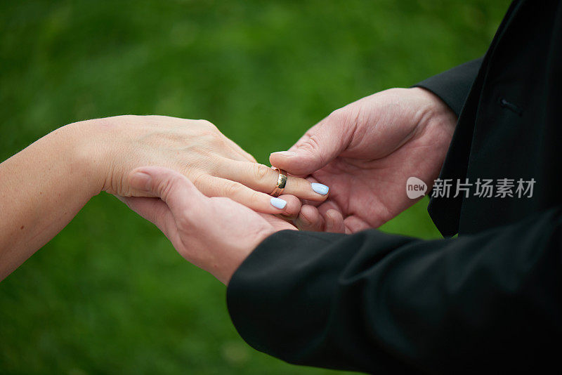 新郎和新娘手拿结婚戒指，一个男人向一个女人求婚，浪漫的婚纱照