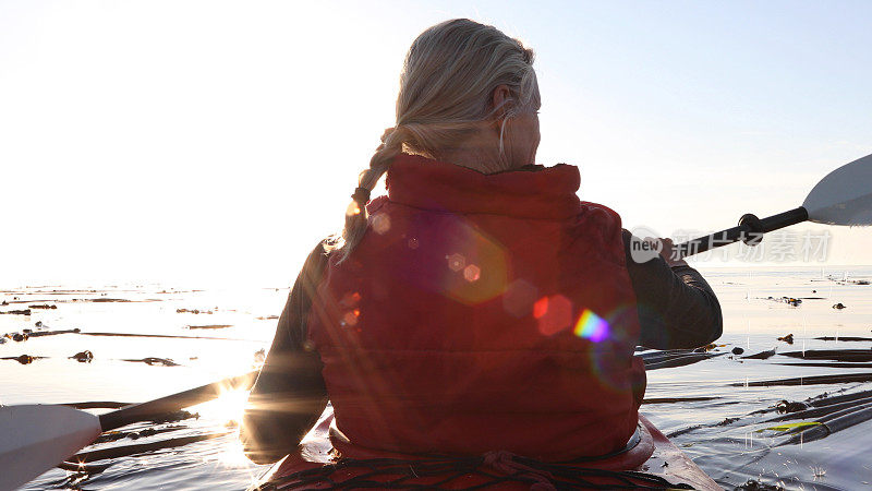女人在日出时划着皮划艇