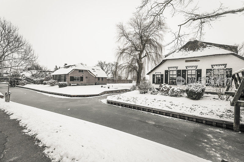 在一个寒冷但美丽而平静的冬天，Giethoorn村的运河和积雪