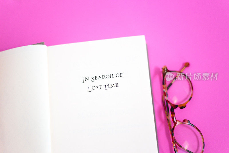 打开书，标题页:寻找失去的时间，粉红色的背景