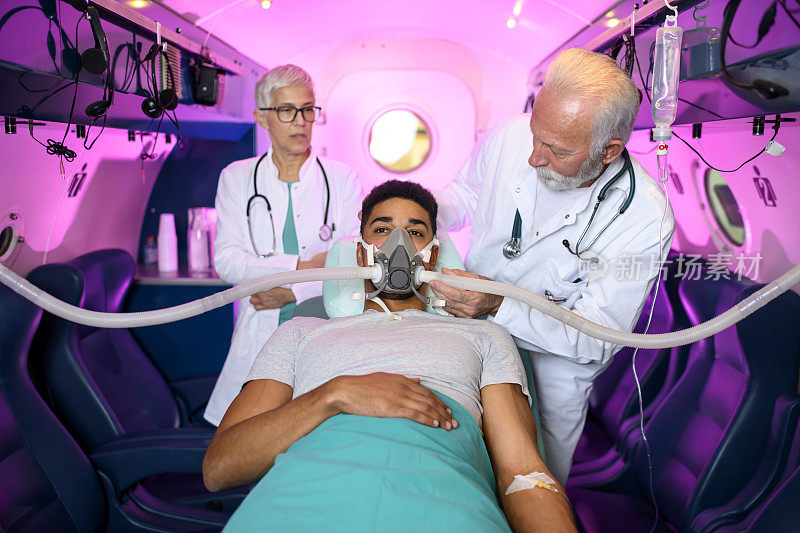 一名医生和一名护士准备病人在高压氧腔内进行HBOT治疗