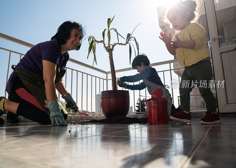 新冠肺炎隔离期间，母亲和儿童在阳台上园艺