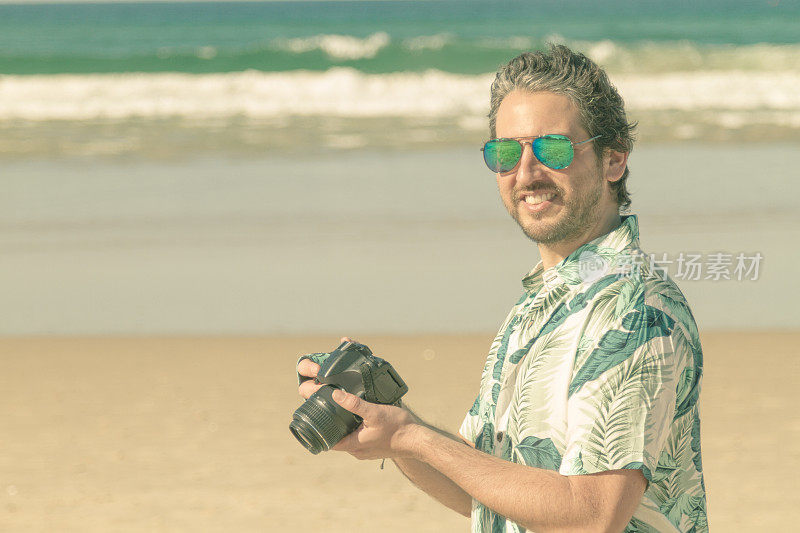 快乐的摄影师在海滩上拍照