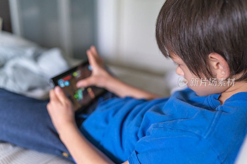 9岁的少数民族男孩在玩手机游戏