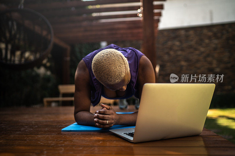 女子在虚拟健身课上做平板支撑