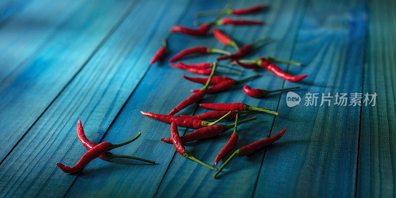 市场新鲜，充满活力，红辣椒铺在抽象的绿松石色的木制背景上，图像的左边和右边有很好的复制空间。