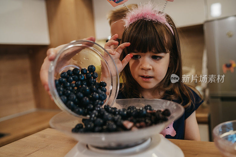 孩子们用厨房秤量蓝莓