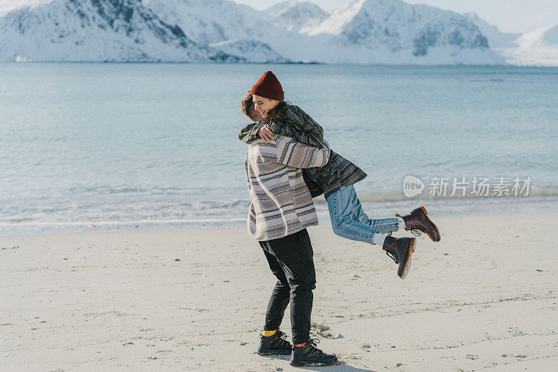 女人和男人有乐趣的海边在冬天罗浮敦岛