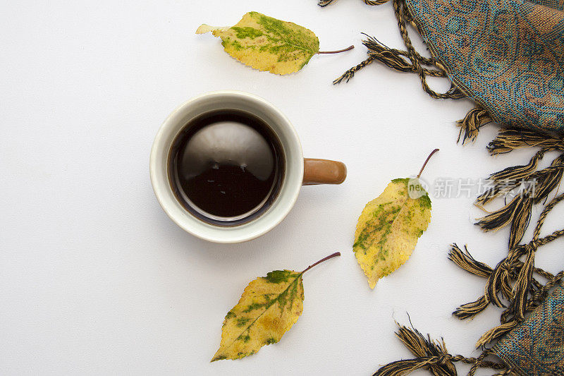 秋天平躺着咖啡，落叶和一条围巾。舒适的思绪心情