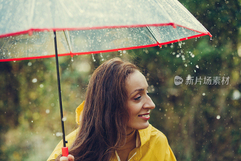 雨中快乐的女孩站在外面