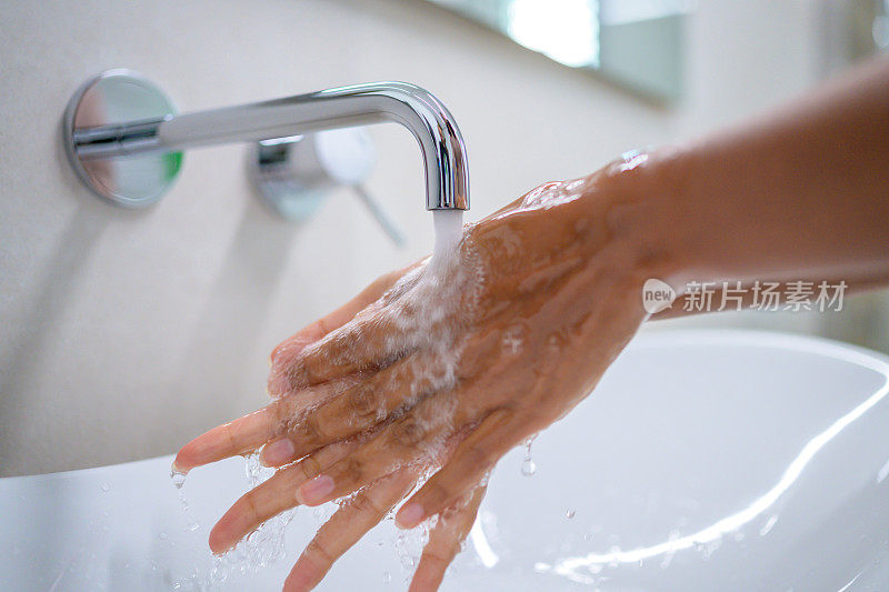 在洗脸盆内的流动水下洗手