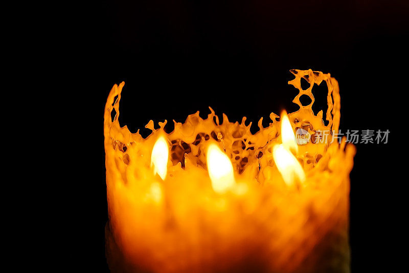 黑色的背景上有一支大的蜂蜡蜡烛，七支小的蜂蜡蜡烛合在一起，火正在燃烧
火焰传播。耶路撒冷圣墓神庙的圣火