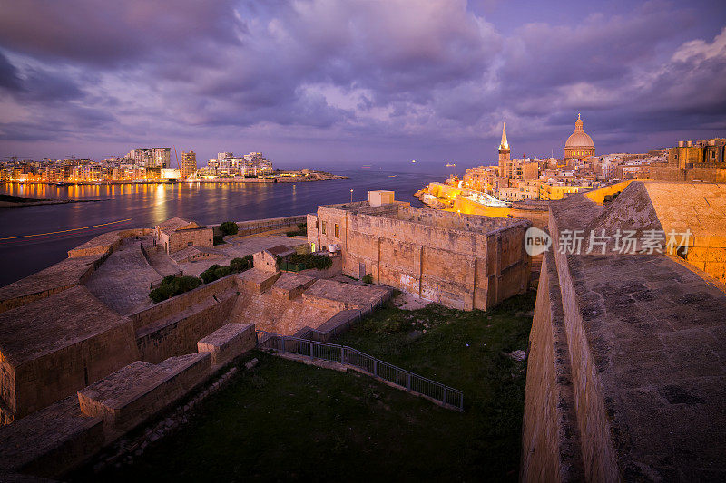 瓦莱塔老城的夜景，圣保罗大教堂和Marsamxett港口与Sliema，马耳他的现代住宅区