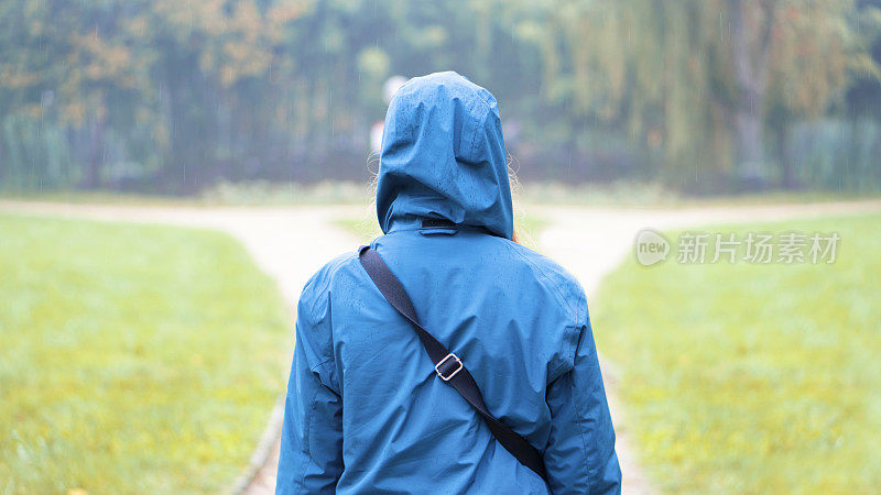 那个穿蓝色雨衣，带着提包的人朝森林的入口走去。他走在树林里。他的脸看不见，因为他从后面害羞。在阳光明媚的日子里照的。一个雨天。这就是彩虹出现的原因。