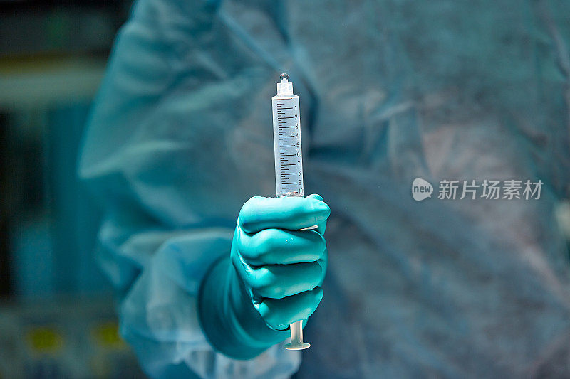 医生的手拿著注射器抵住病人的特写影像。医院手术前采用局部麻醉。选择性聚焦在注射器上。医学的概念