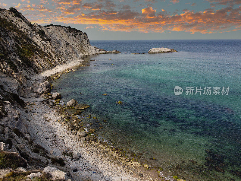 蓝绿色的大海，多石的海滩和令人印象深刻的天空