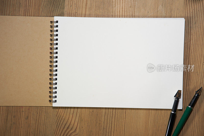 木桌面上的空白素描本