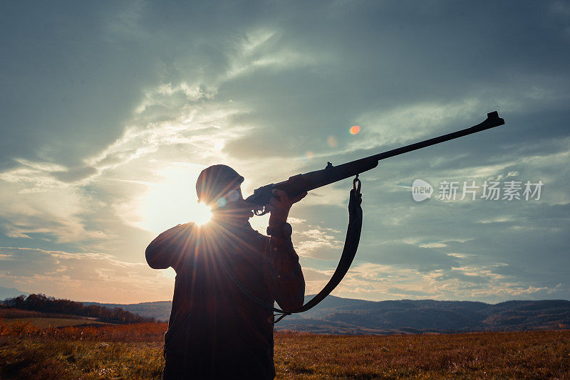 运动射击和狩猎——日落时分手持步枪的男子