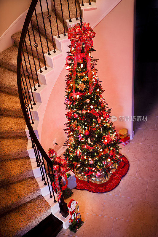 圣诞节:螺旋形楼梯旁装饰精美的圣诞树。