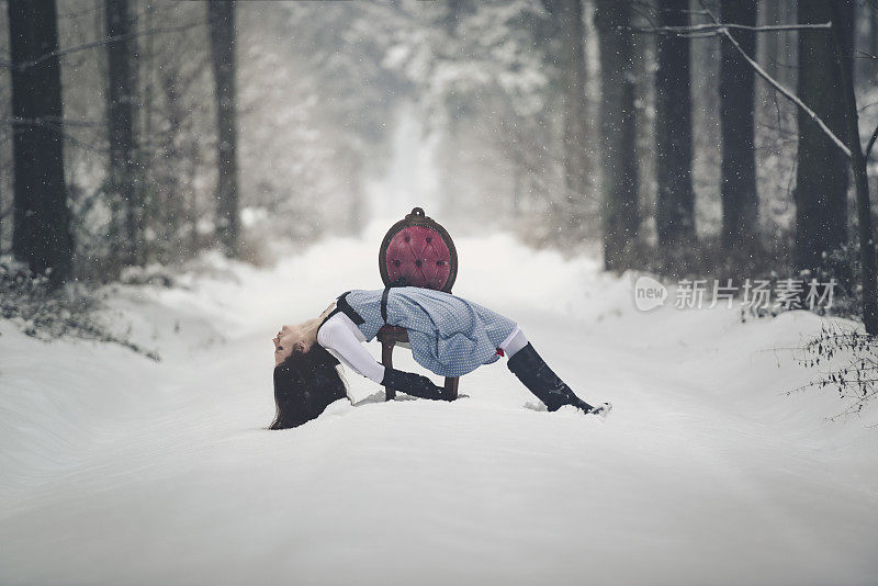 年轻女子红色复古椅子雪地森林