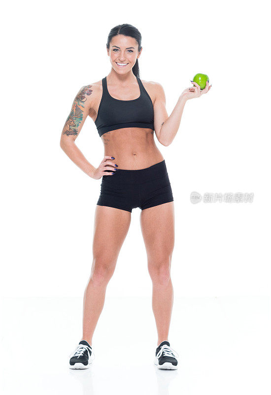 微笑的女运动员拿着苹果