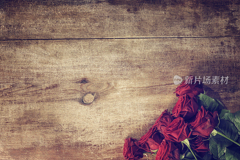 木质背景上的浪漫的红玫瑰花束