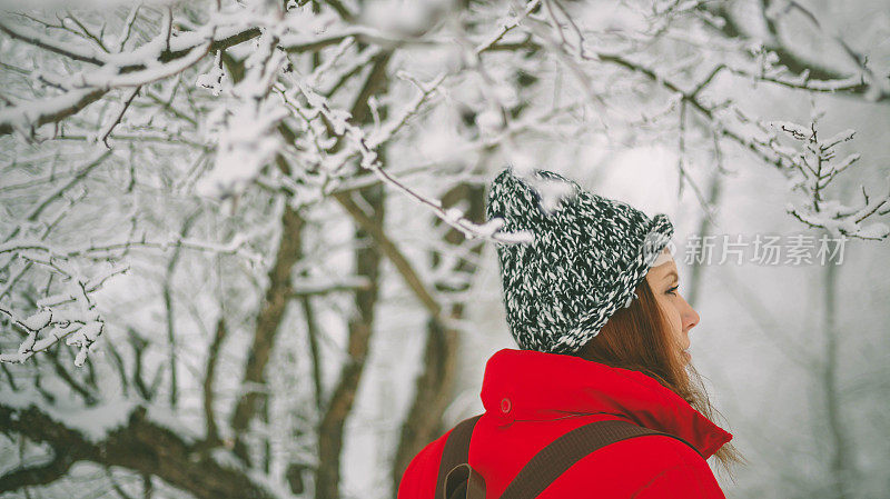 冬季运动活动。女徒步旅行者背包和雪鞋在雪地上的雪鞋