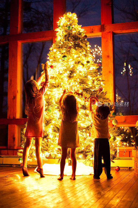 三个孩子在装饰圣诞树