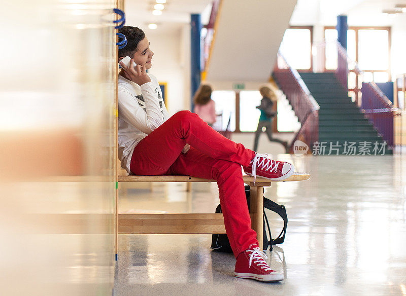一个青少年在学校用手机