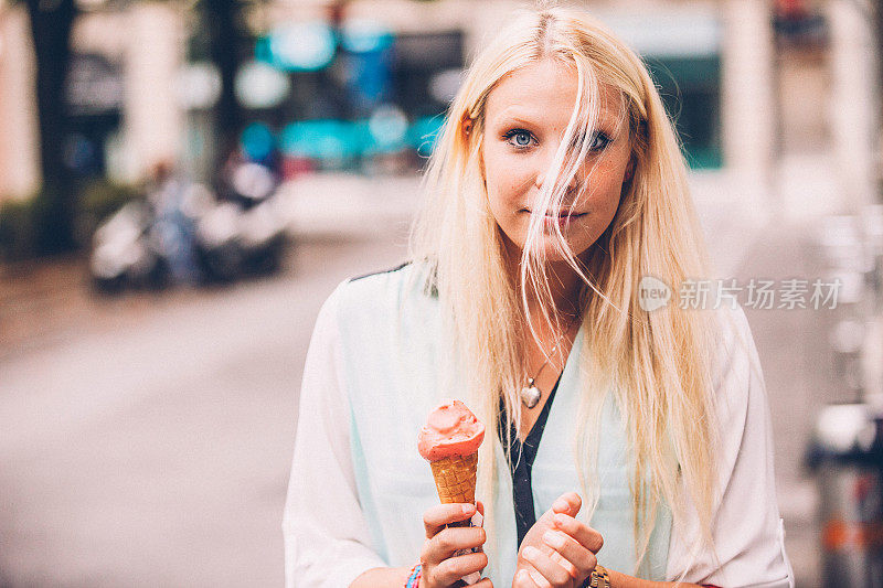 一个金发年轻女人的肖像拿着一个冰淇淋